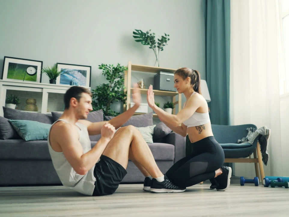 a man and woman sitting on the floor in front of a couch